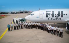 a group of people standing in front of a plane