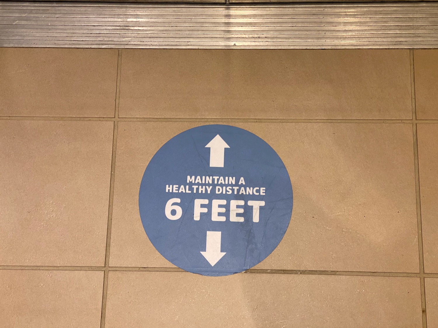 a blue circle with white text on it on a tile floor