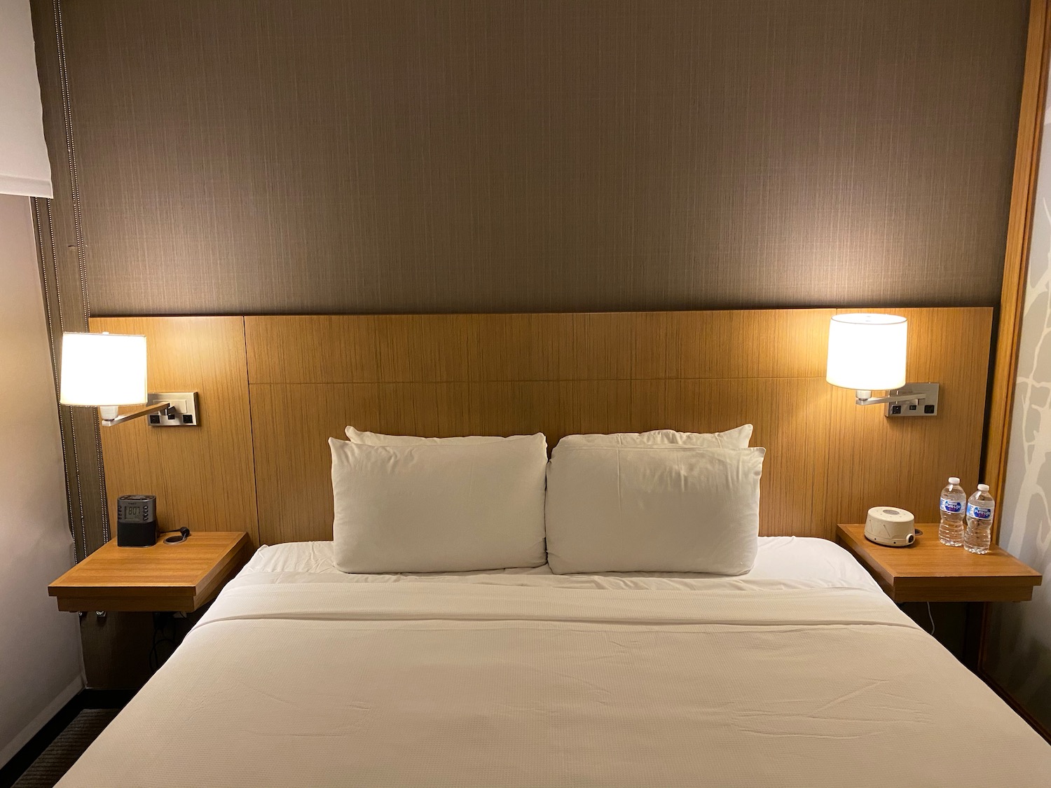 a bed with white sheets and a wooden headboard