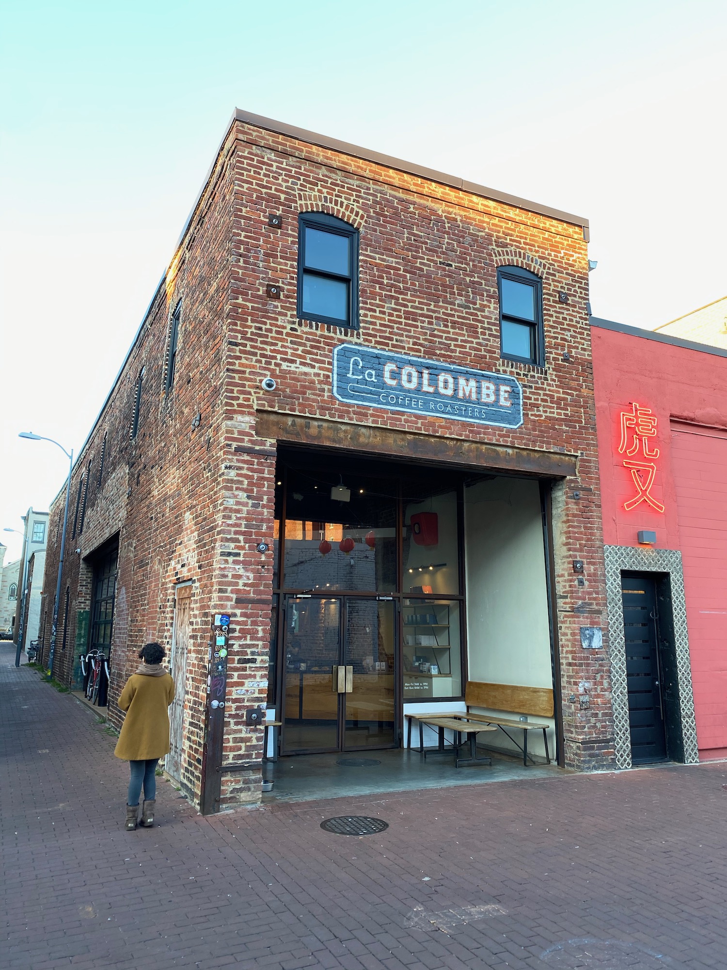 a woman standing in front of a brick building