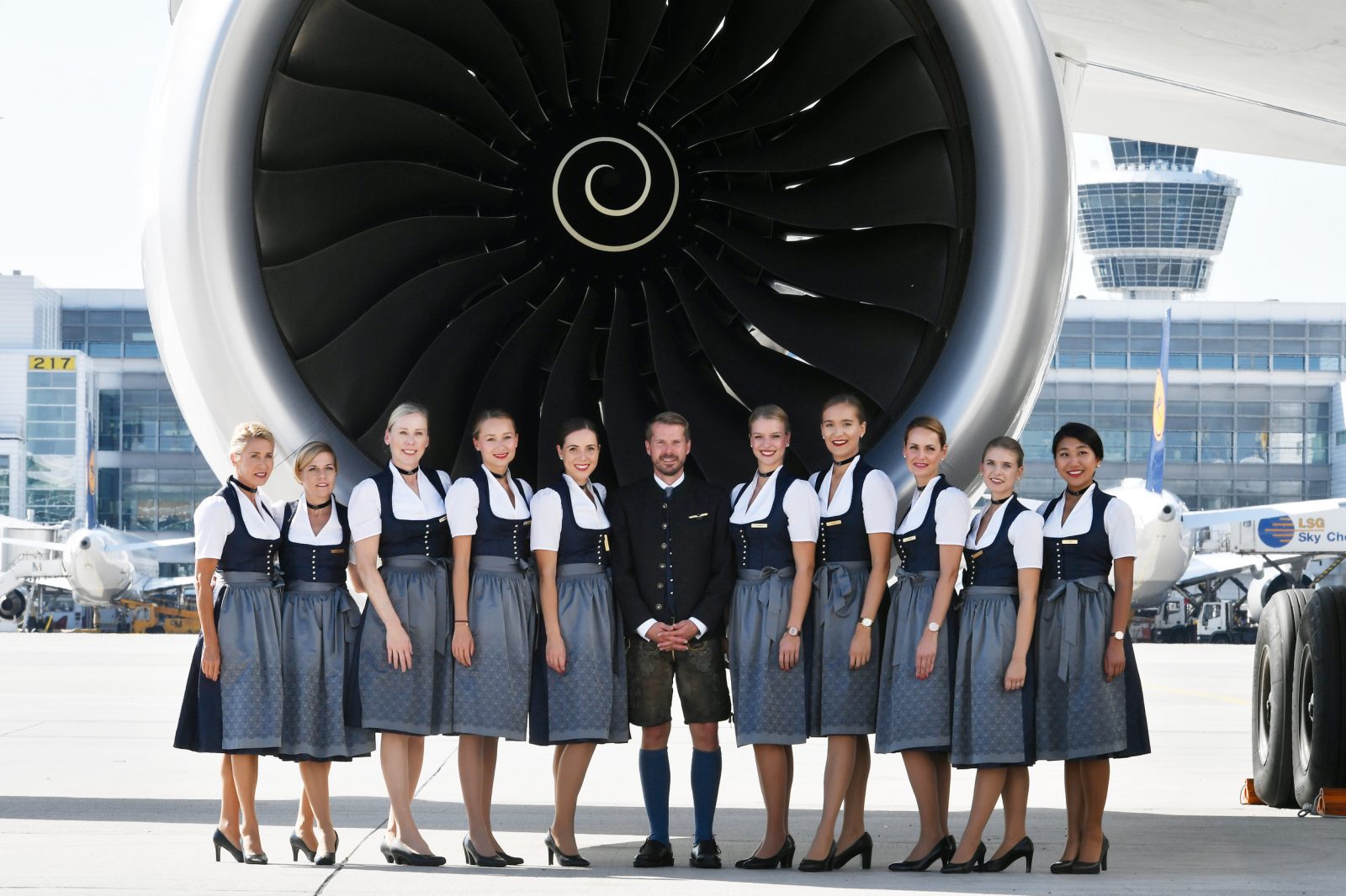 a group of people standing in front of a large jet engine