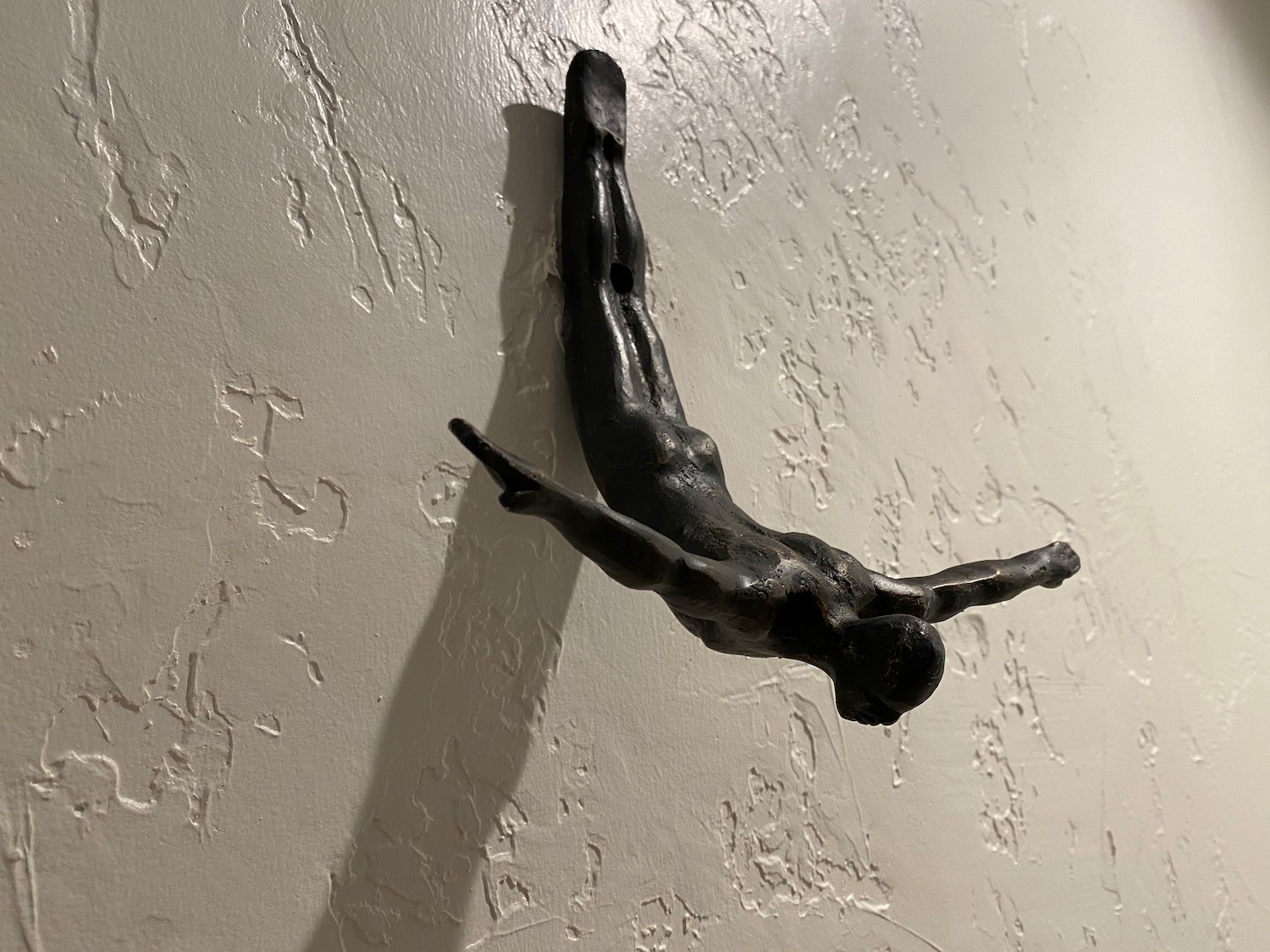 a black statue of a man upside down
