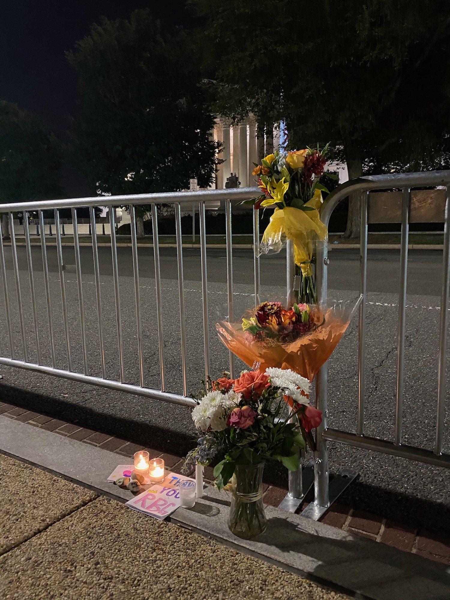 flowers and candles on a fence