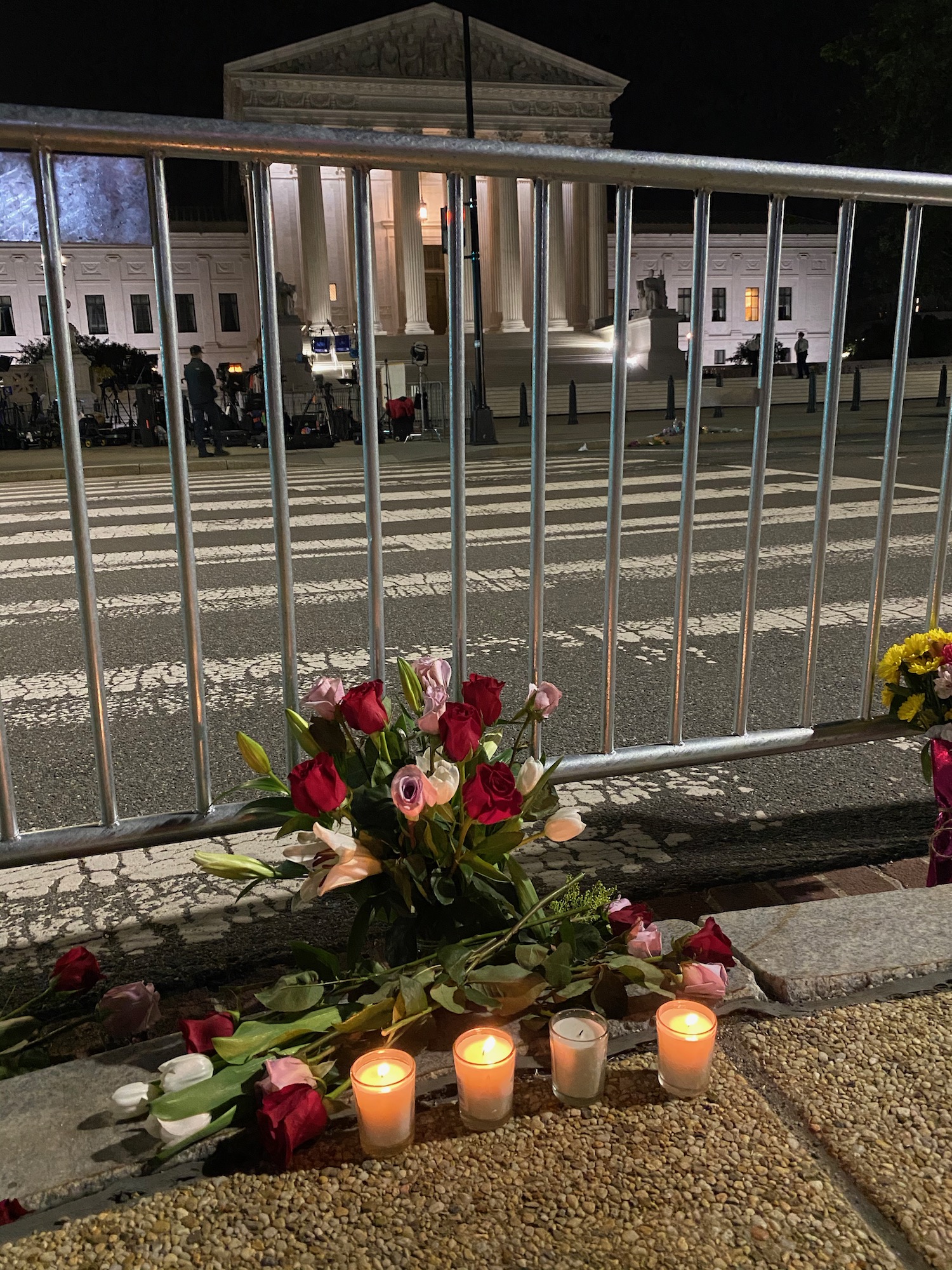 flowers and candles on a sidewalk