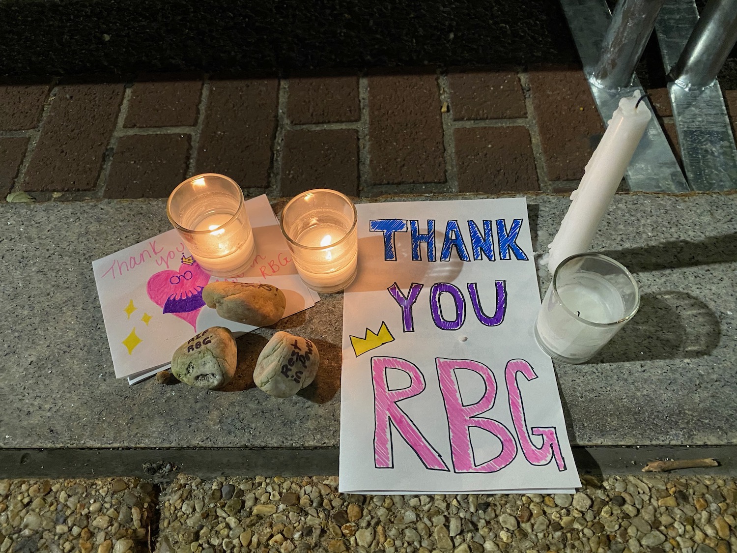 a sign and candles on a stone surface