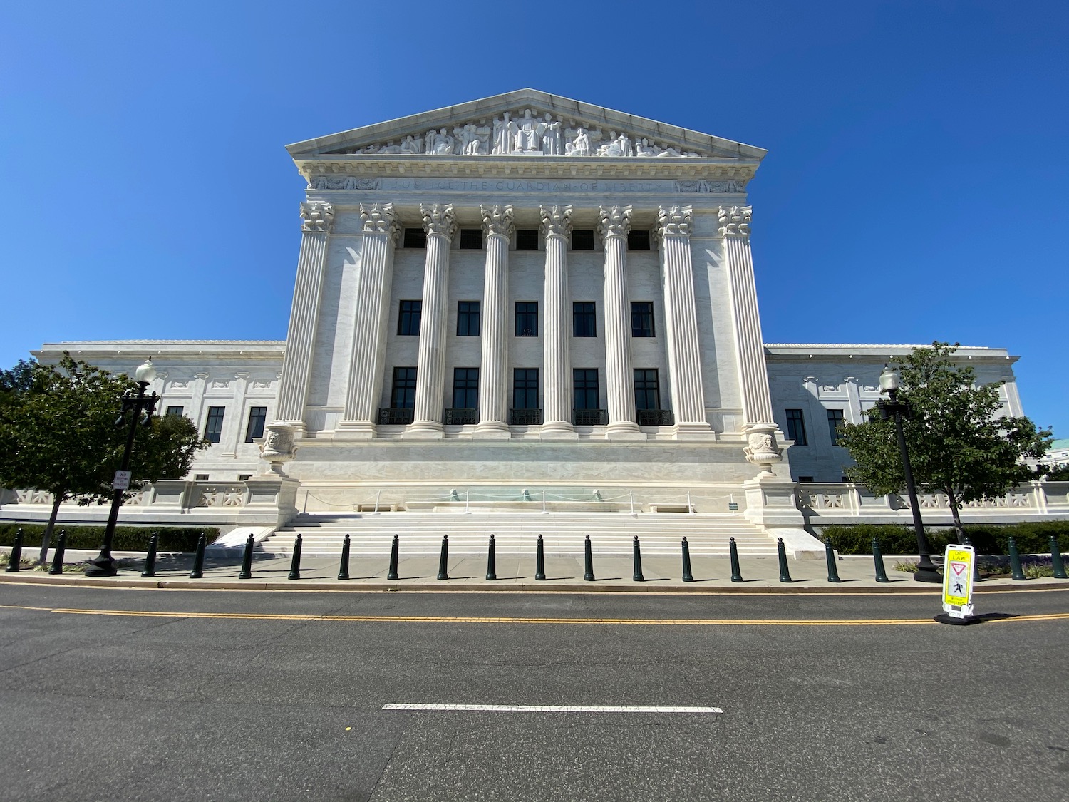 a white building with columns and columns with United States Supreme Court Building in the background