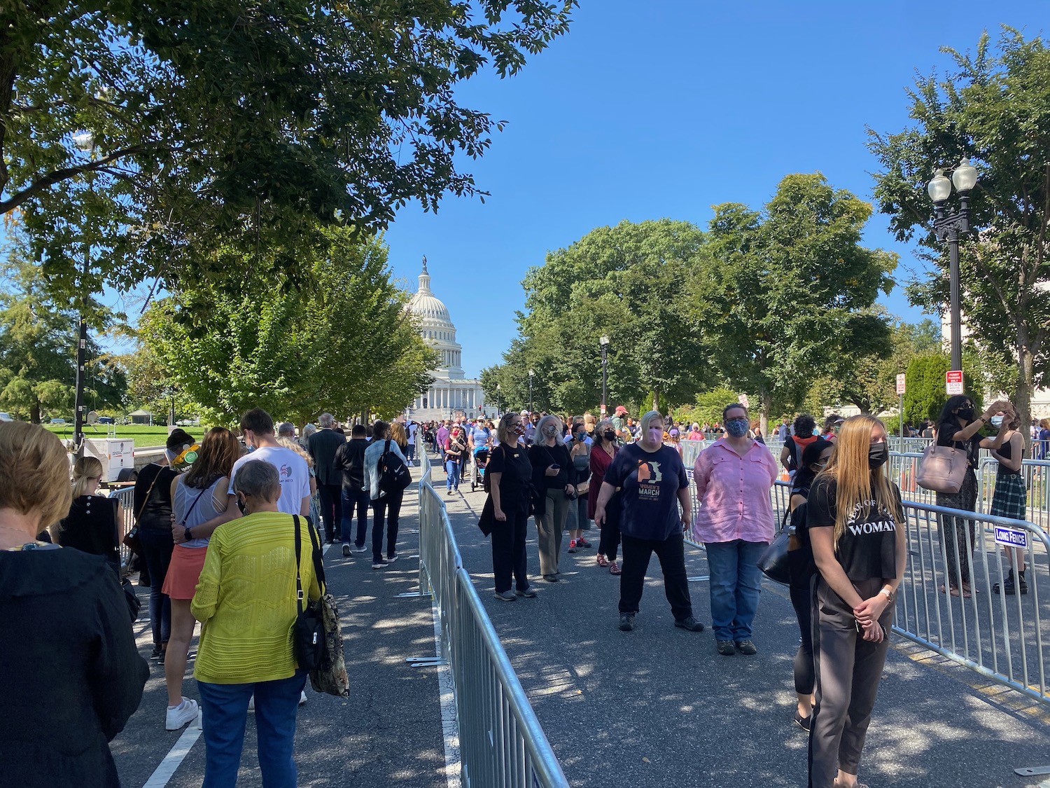 a group of people standing on a sidewalk