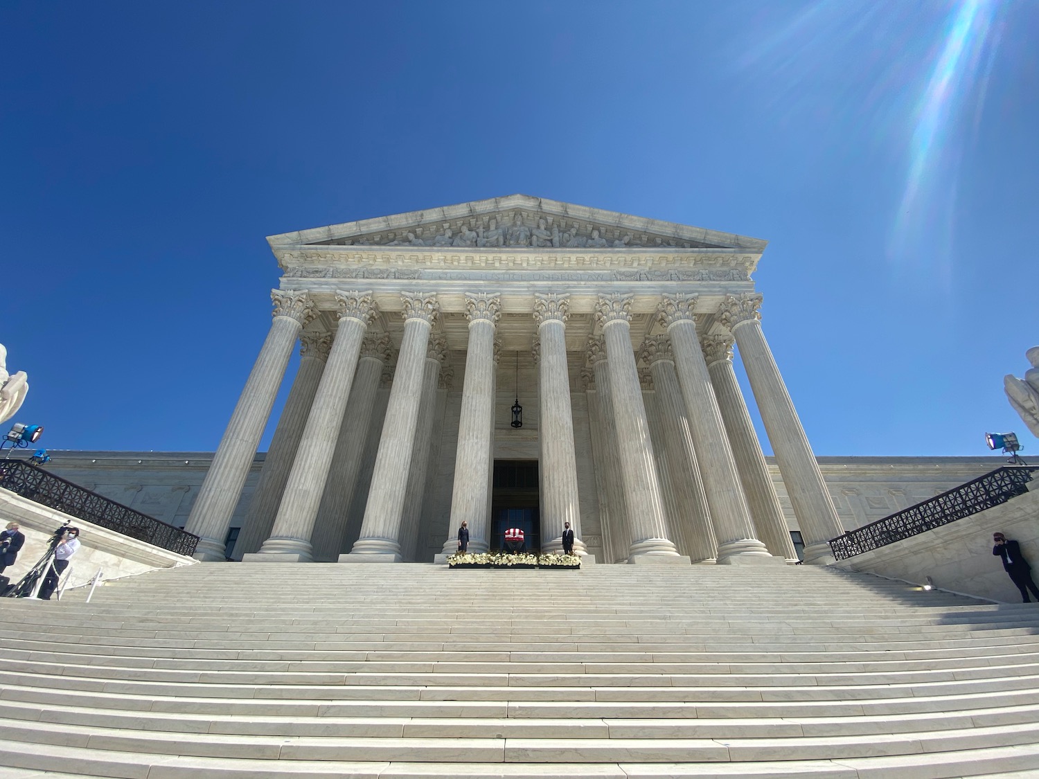 a white building with columns with United States Supreme Court Building in the background