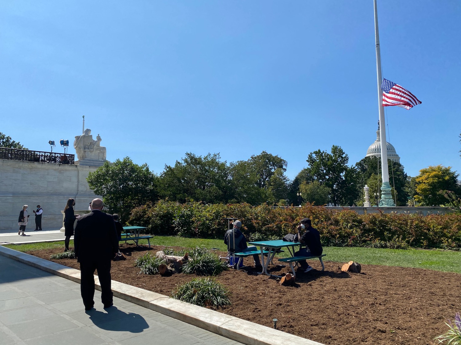 people sitting at a flagpole