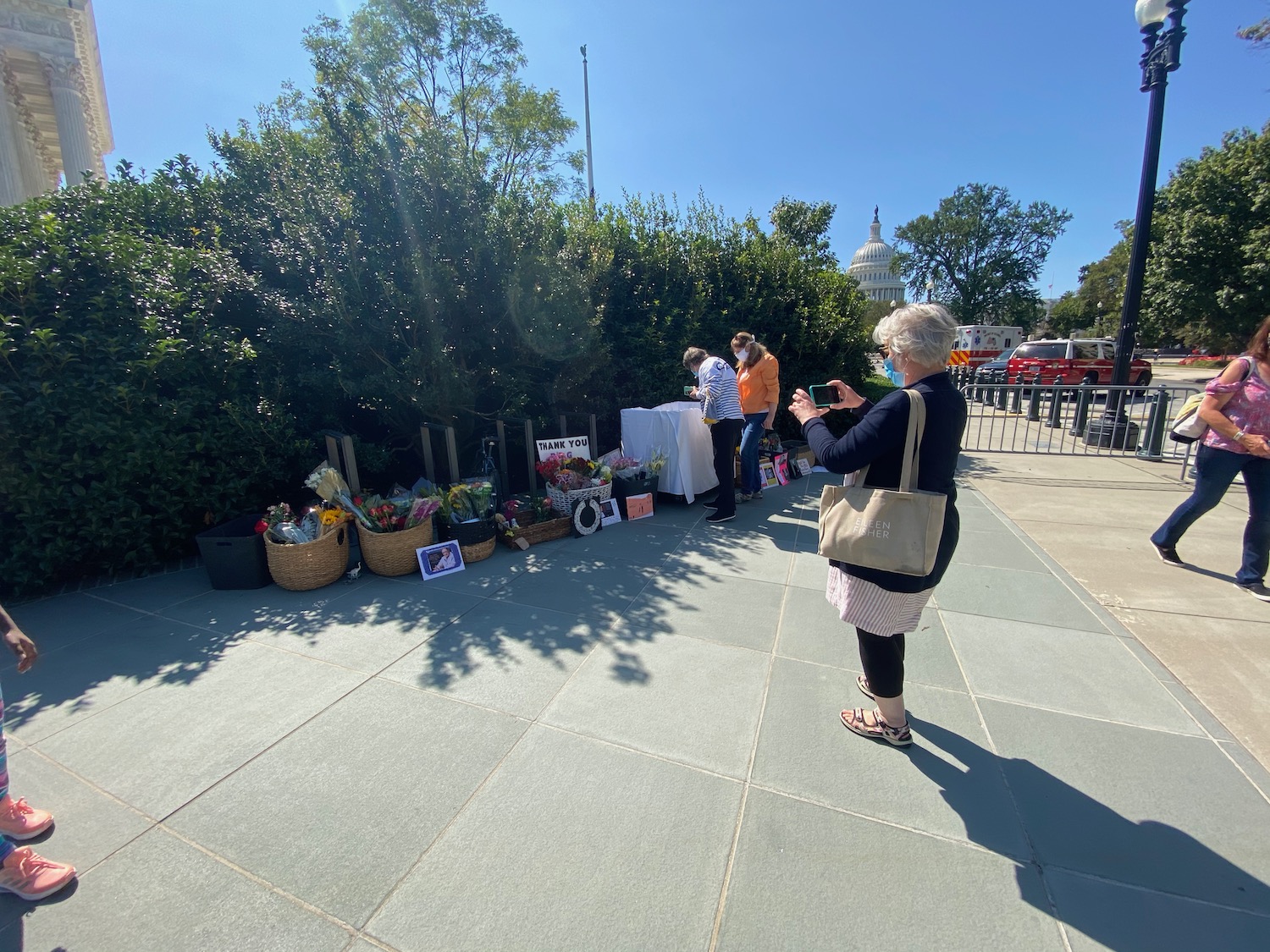 a woman taking a picture of a woman standing outside