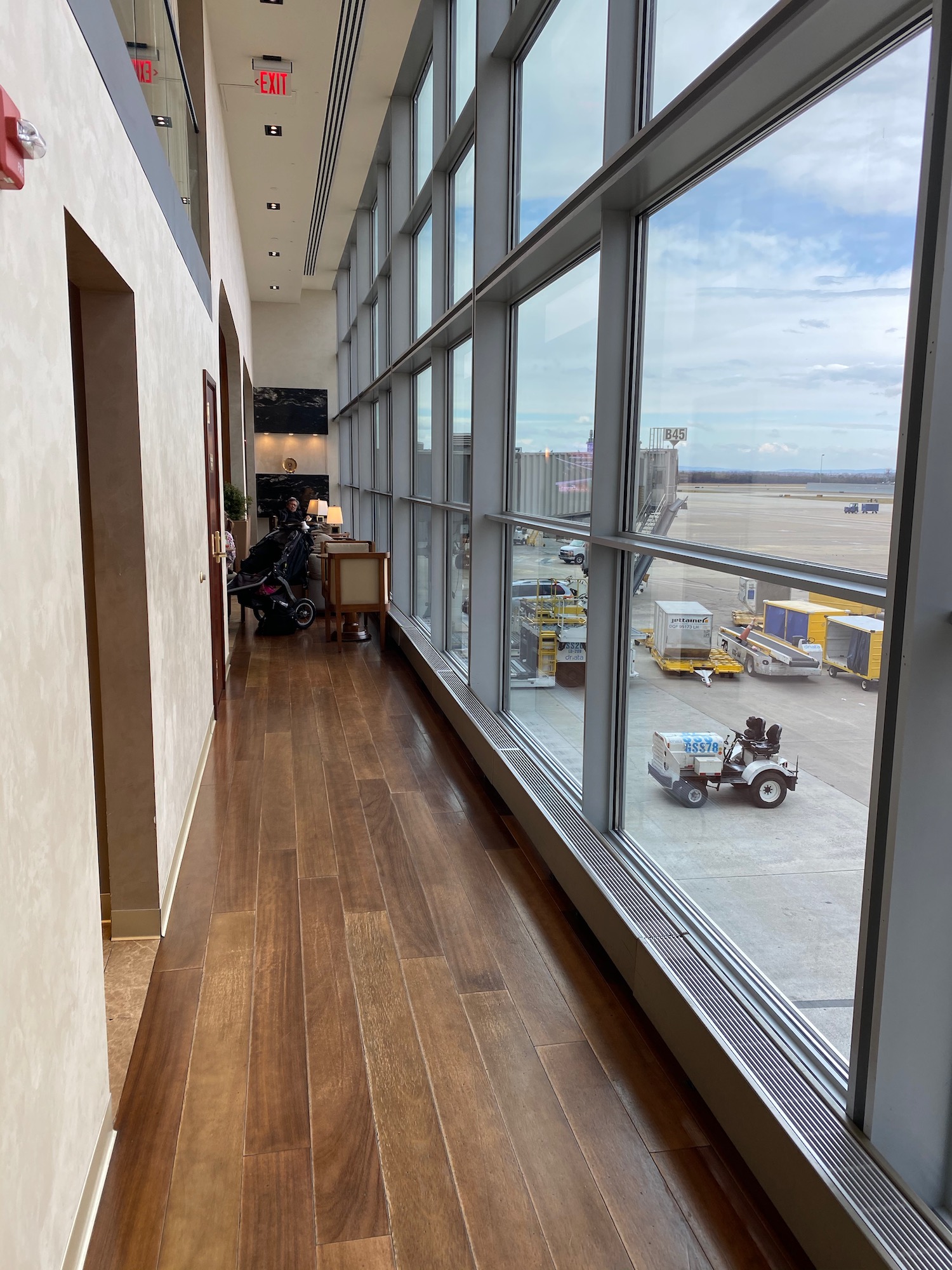 a hallway with large windows and a vehicle on the runway