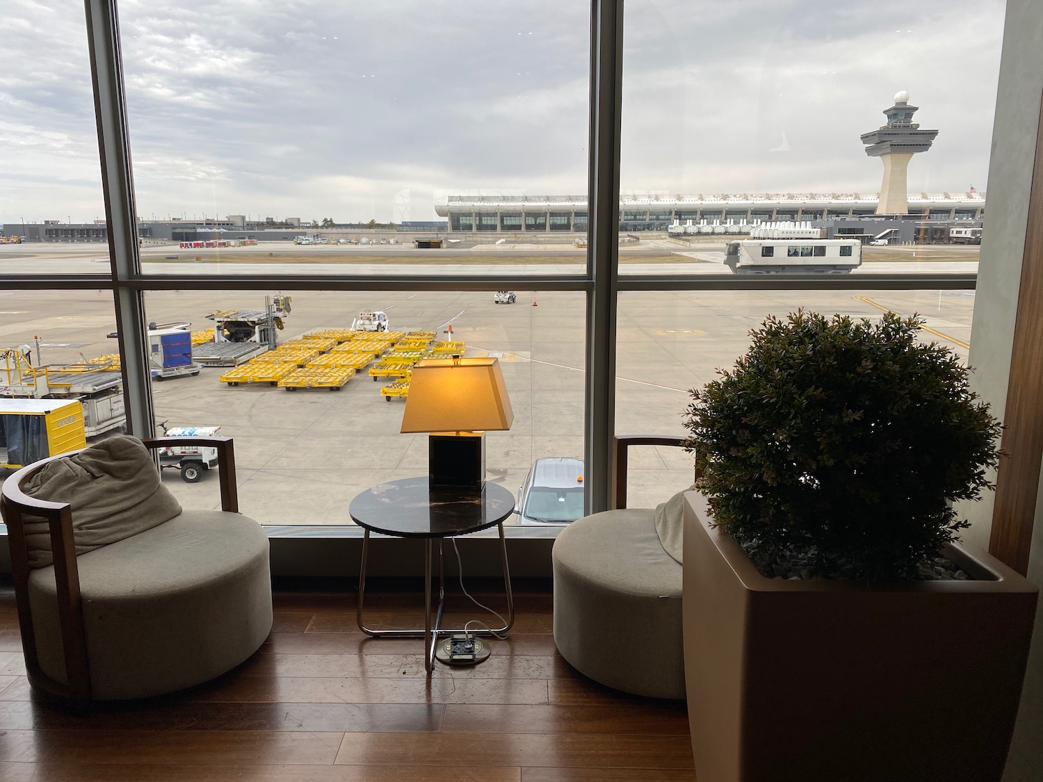 a room with a window and chairs and a lamp