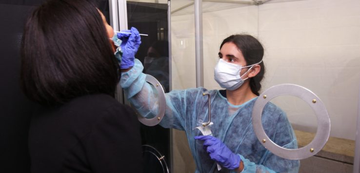 a woman wearing surgical gown and gloves holding a needle