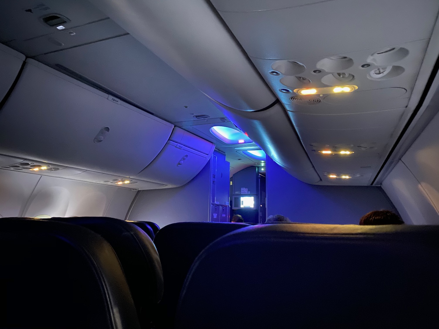 the inside of an airplane with seats and lights