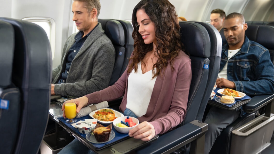 a woman sitting in a chair with a tray of food