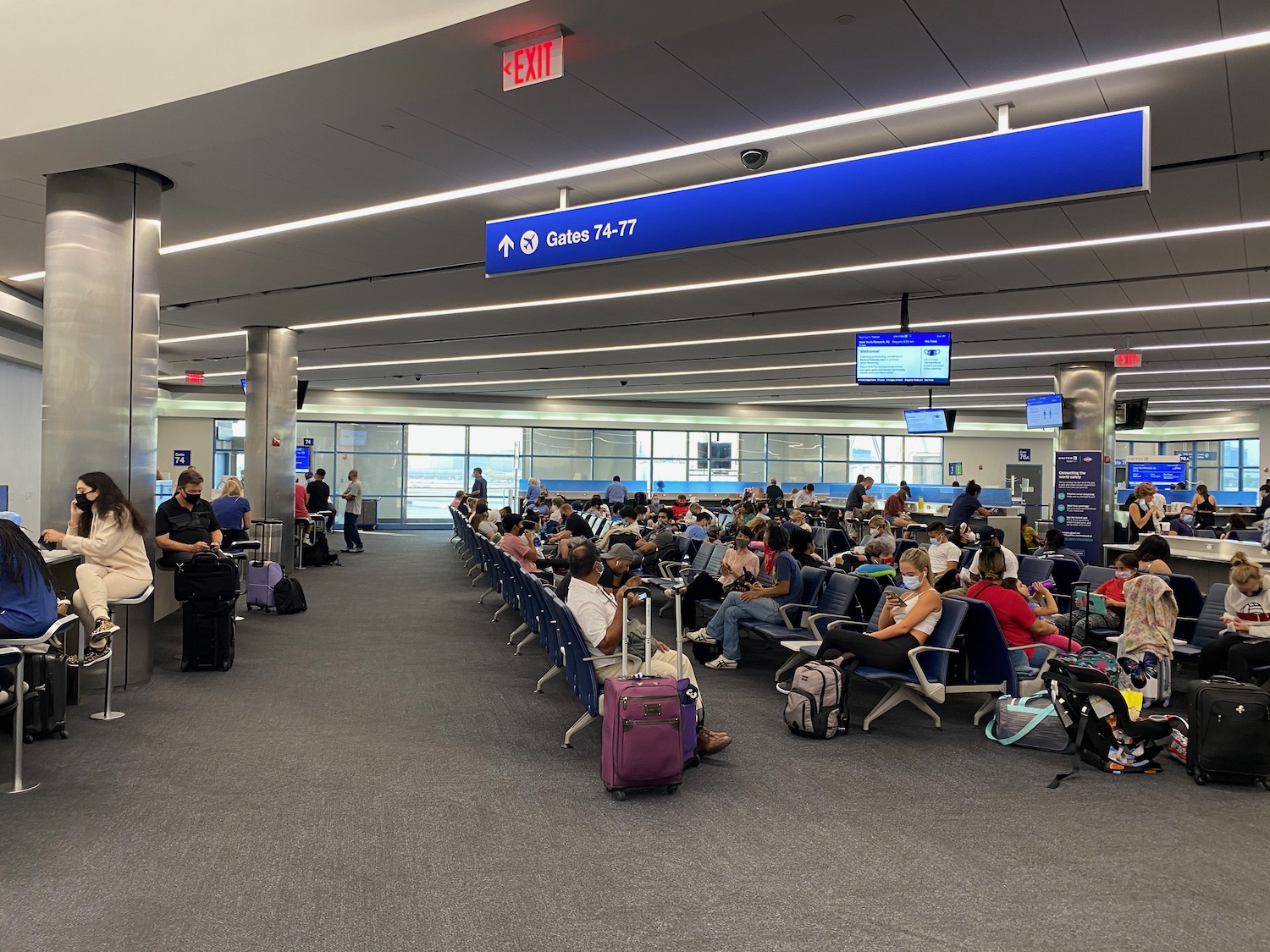 a group of people sitting in chairs in an airport