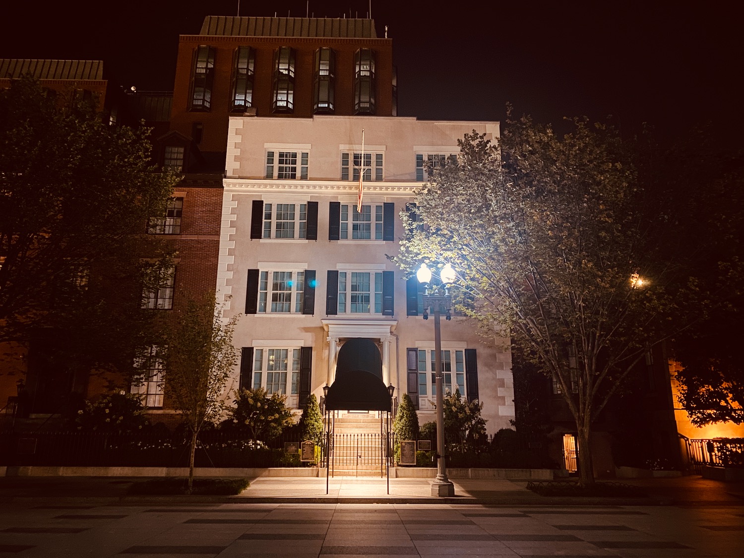 a building with trees and a flag at night