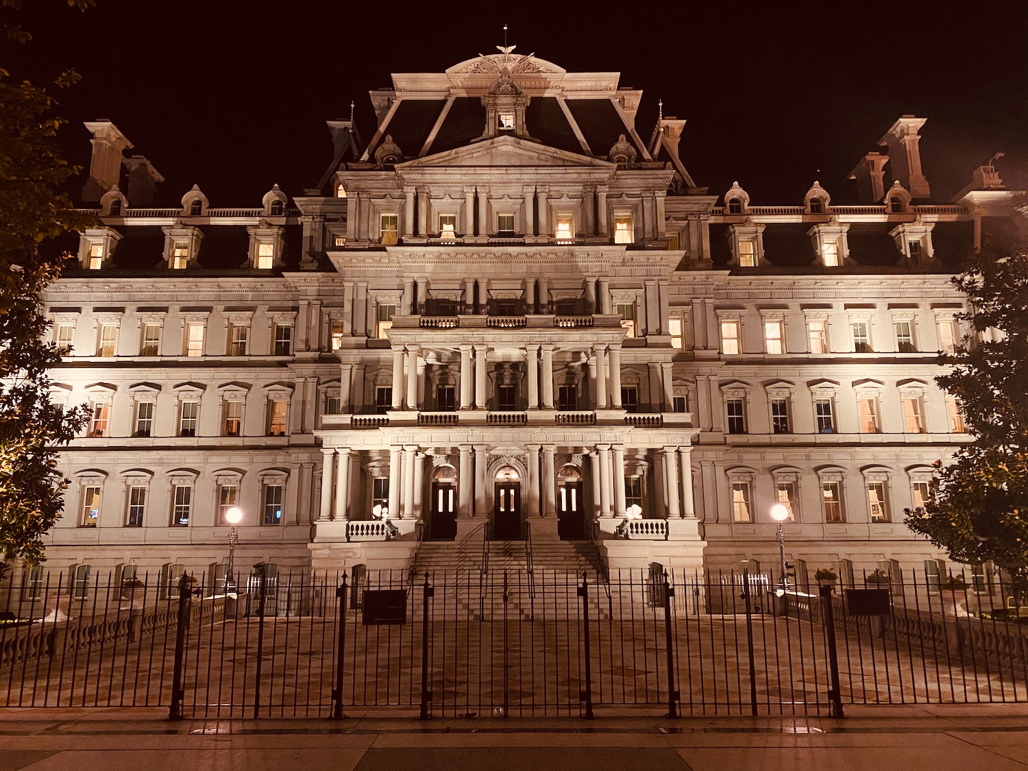 a large building with many windows and a gate with Eisenhower Executive Office Building in the background