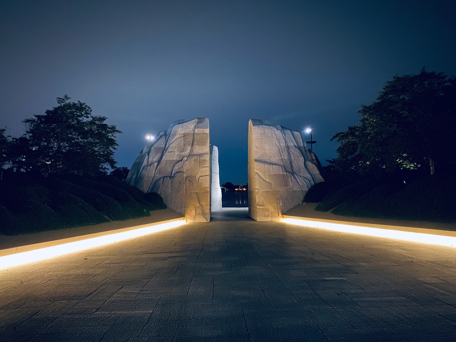 a stone archway with lights at night