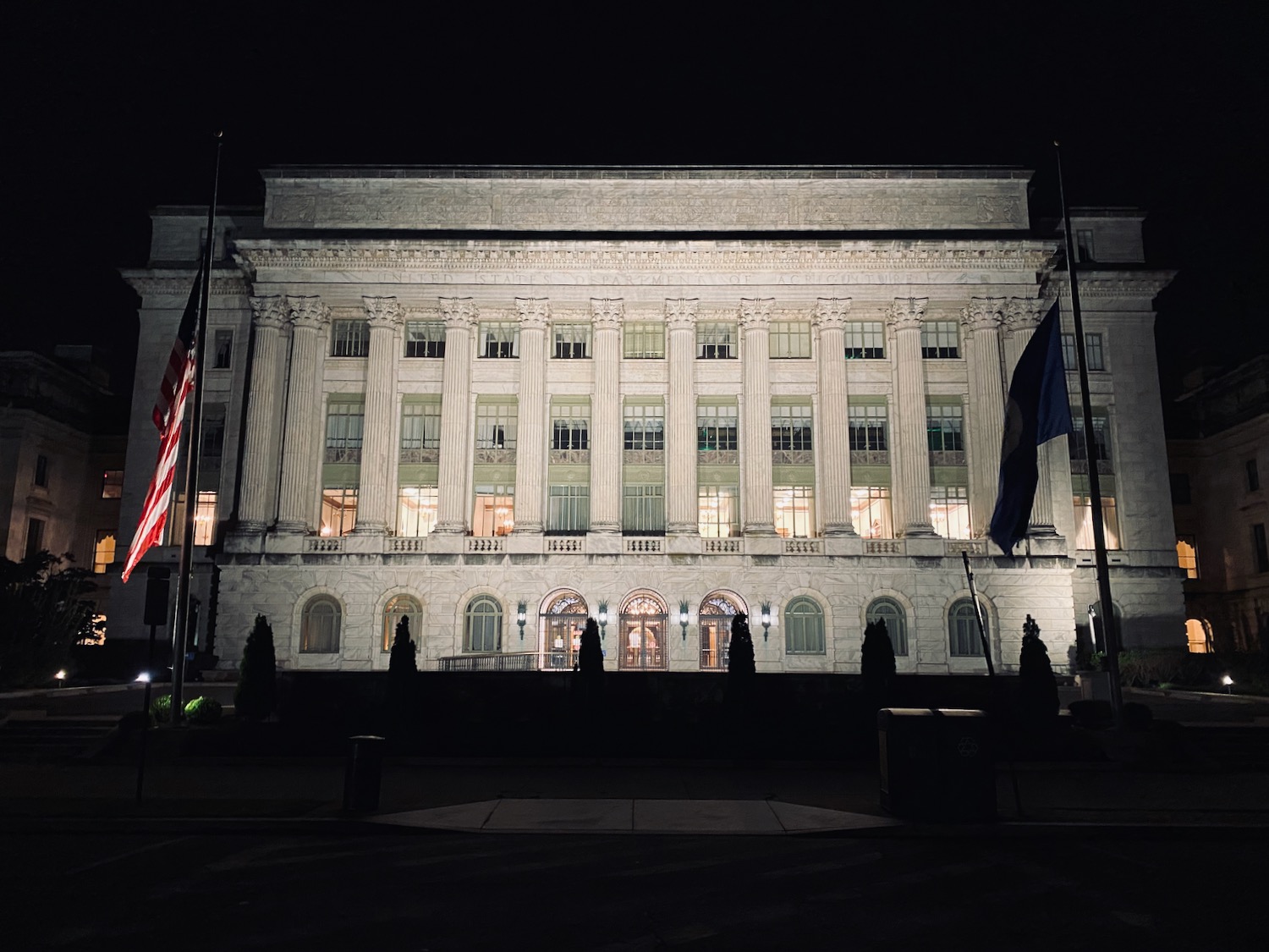 a building with flags in front of it at night