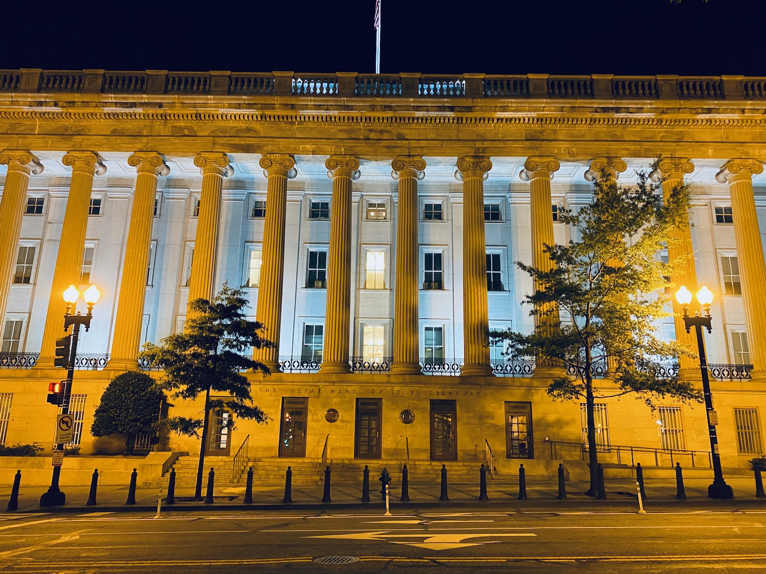 a building with columns and a street at night