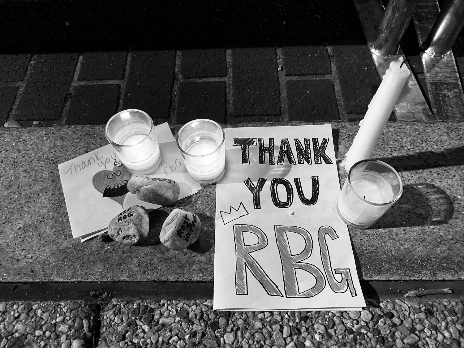 a sign and candles on a stone surface