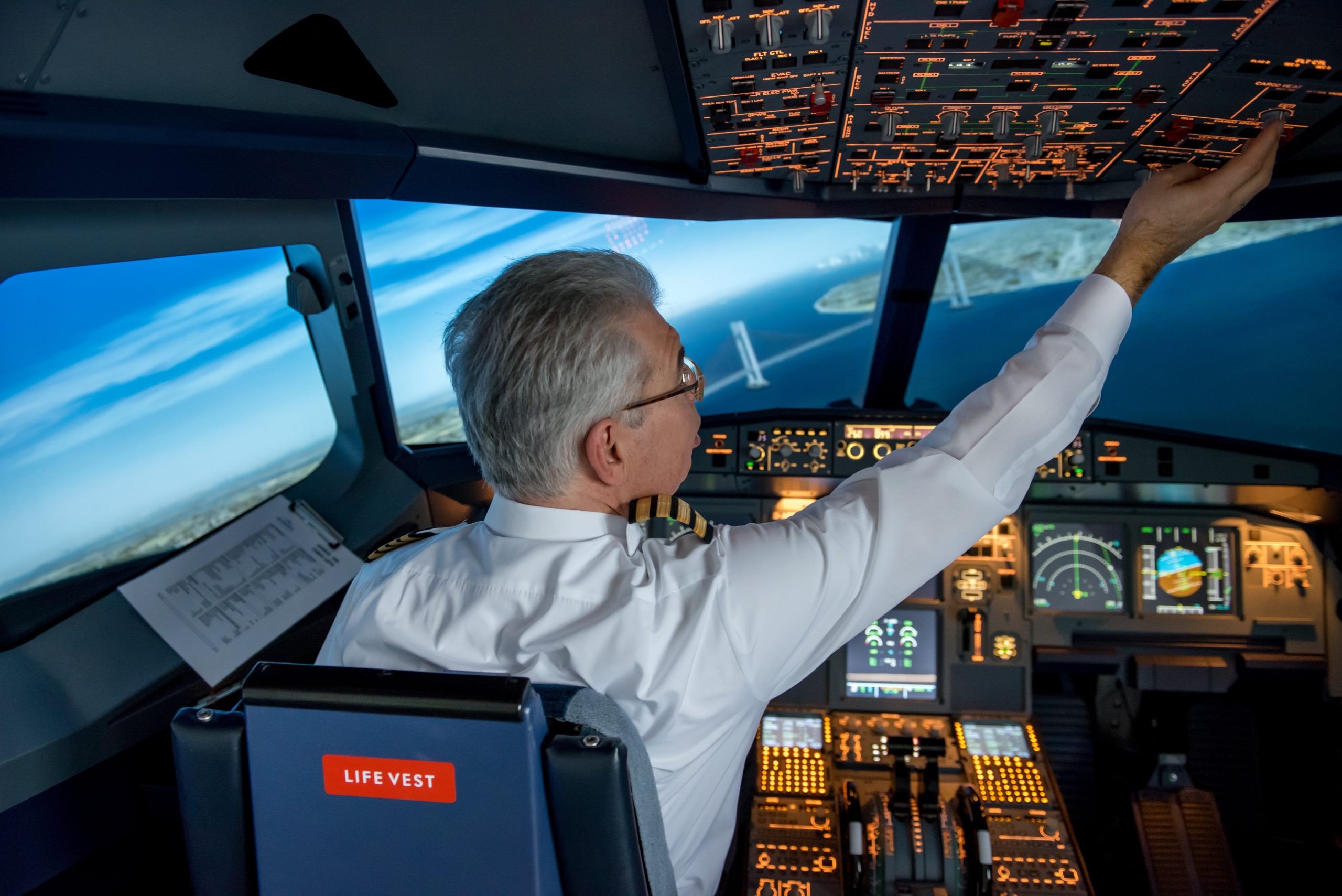 a man in a white shirt pointing at a screen