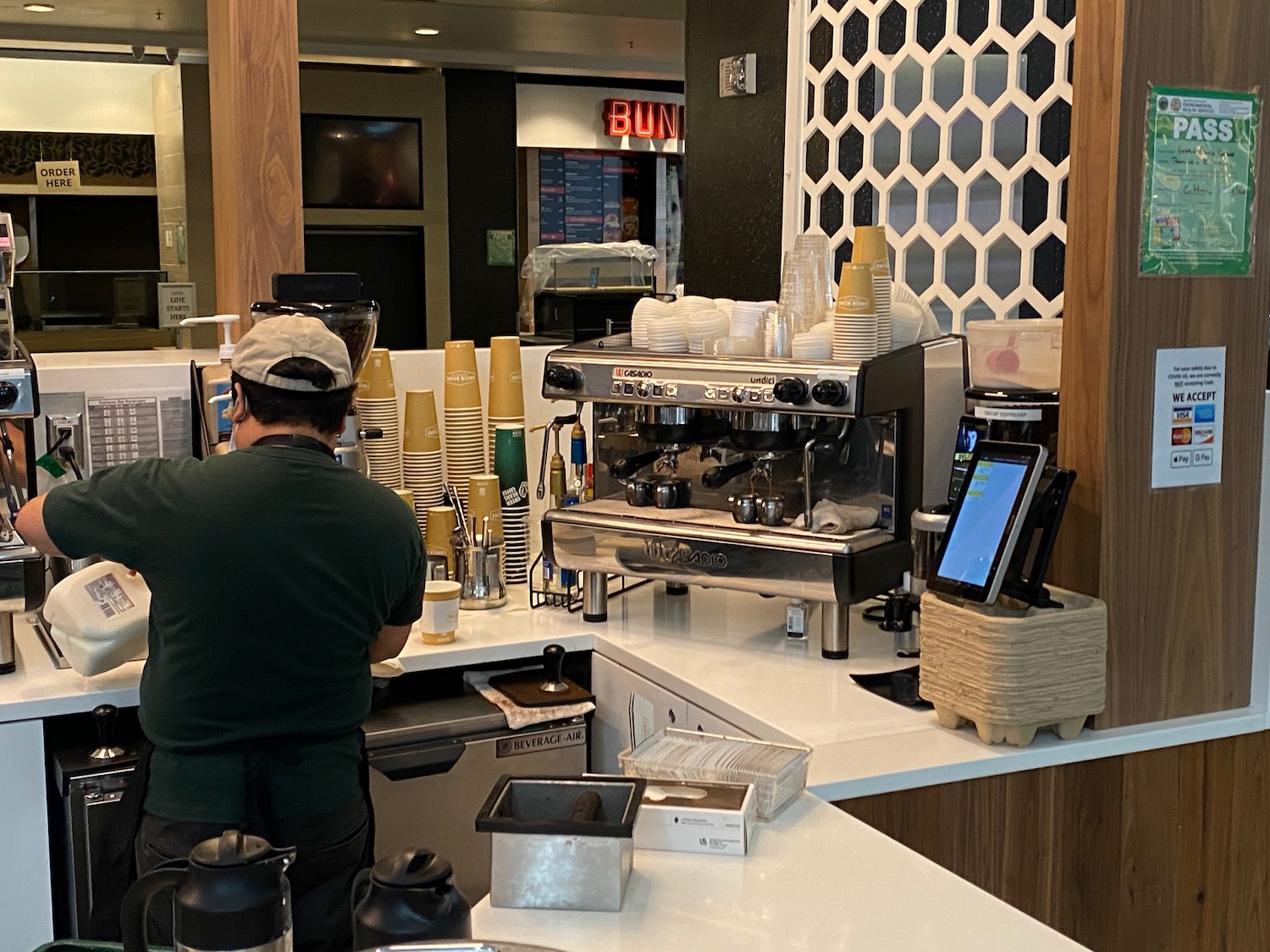 a man standing at a counter with a coffee machine