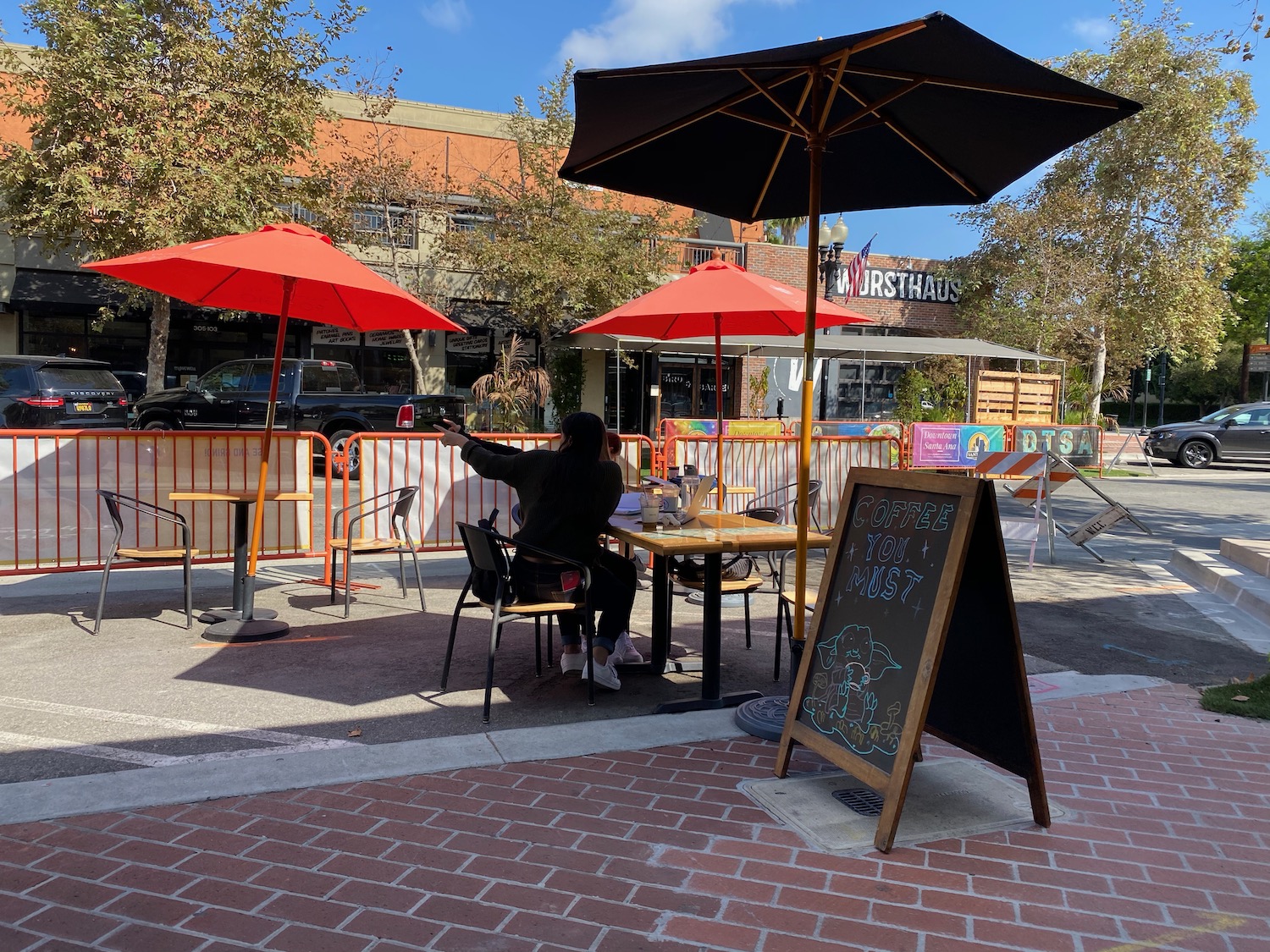 a person sitting at a table with umbrellas