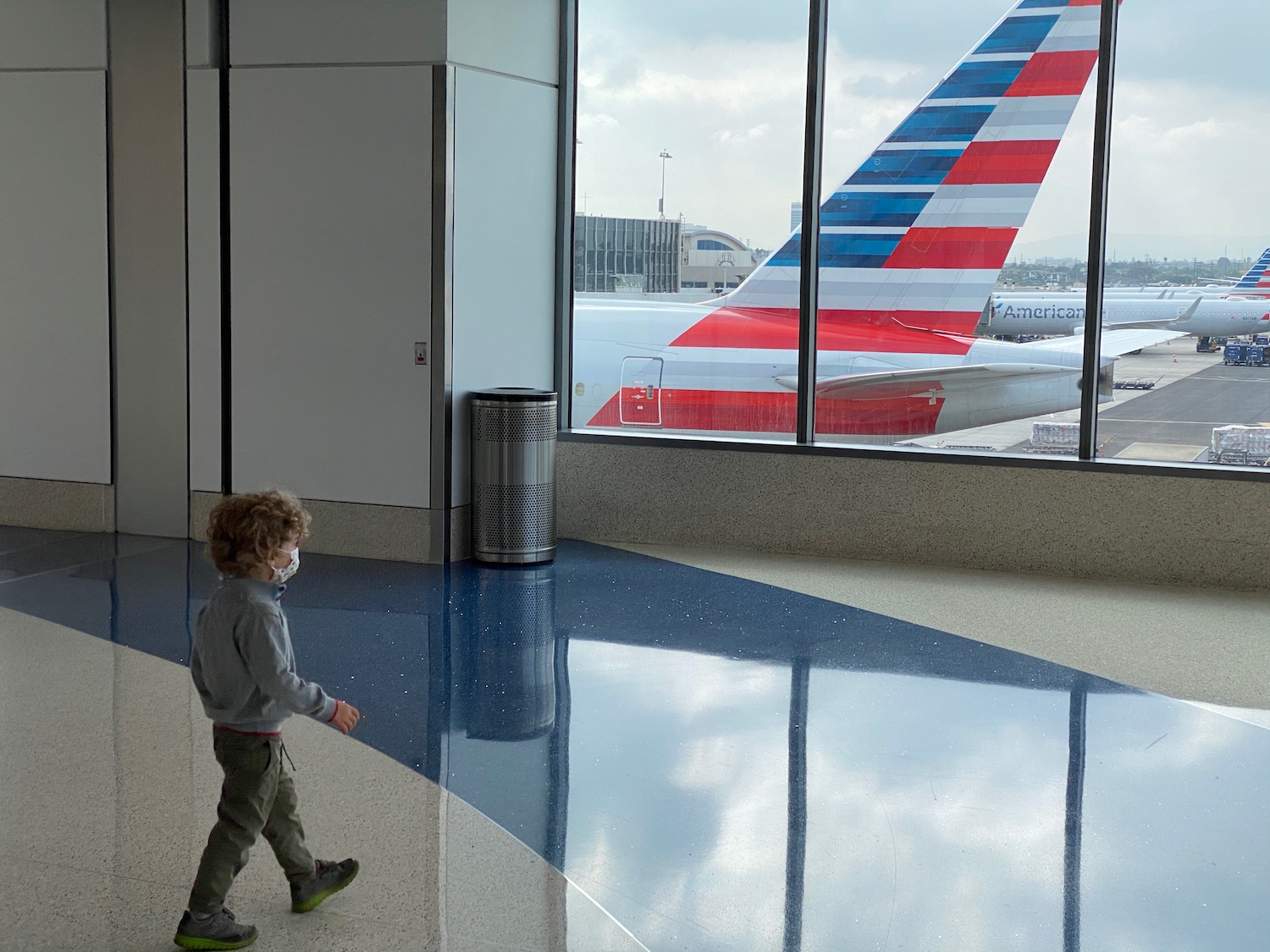 a child walking in a room with a plane in the background