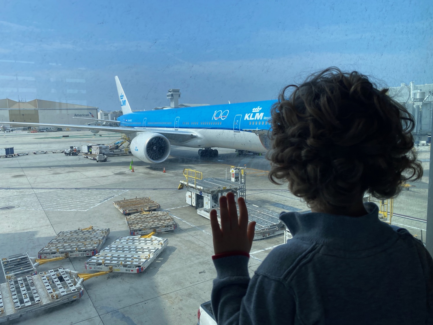 a child looking out a window at an airplane