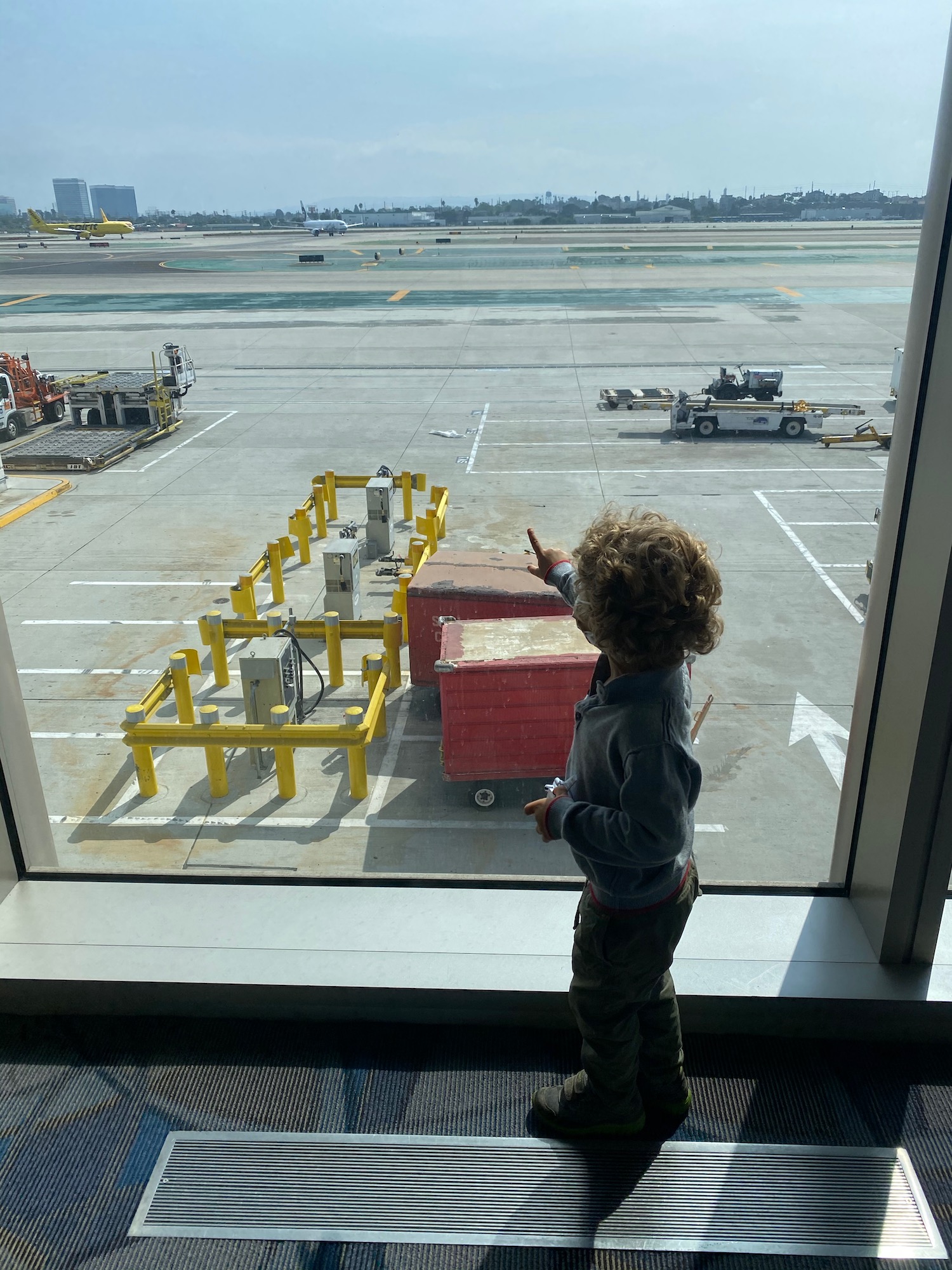 a child looking out a window at an airport