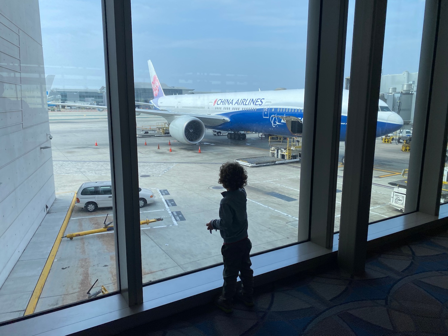 a child looking out a window at an airplane