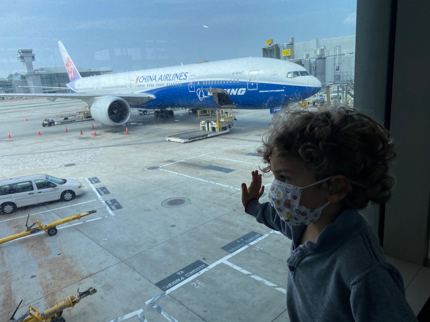 a child looking out a window at an airplane