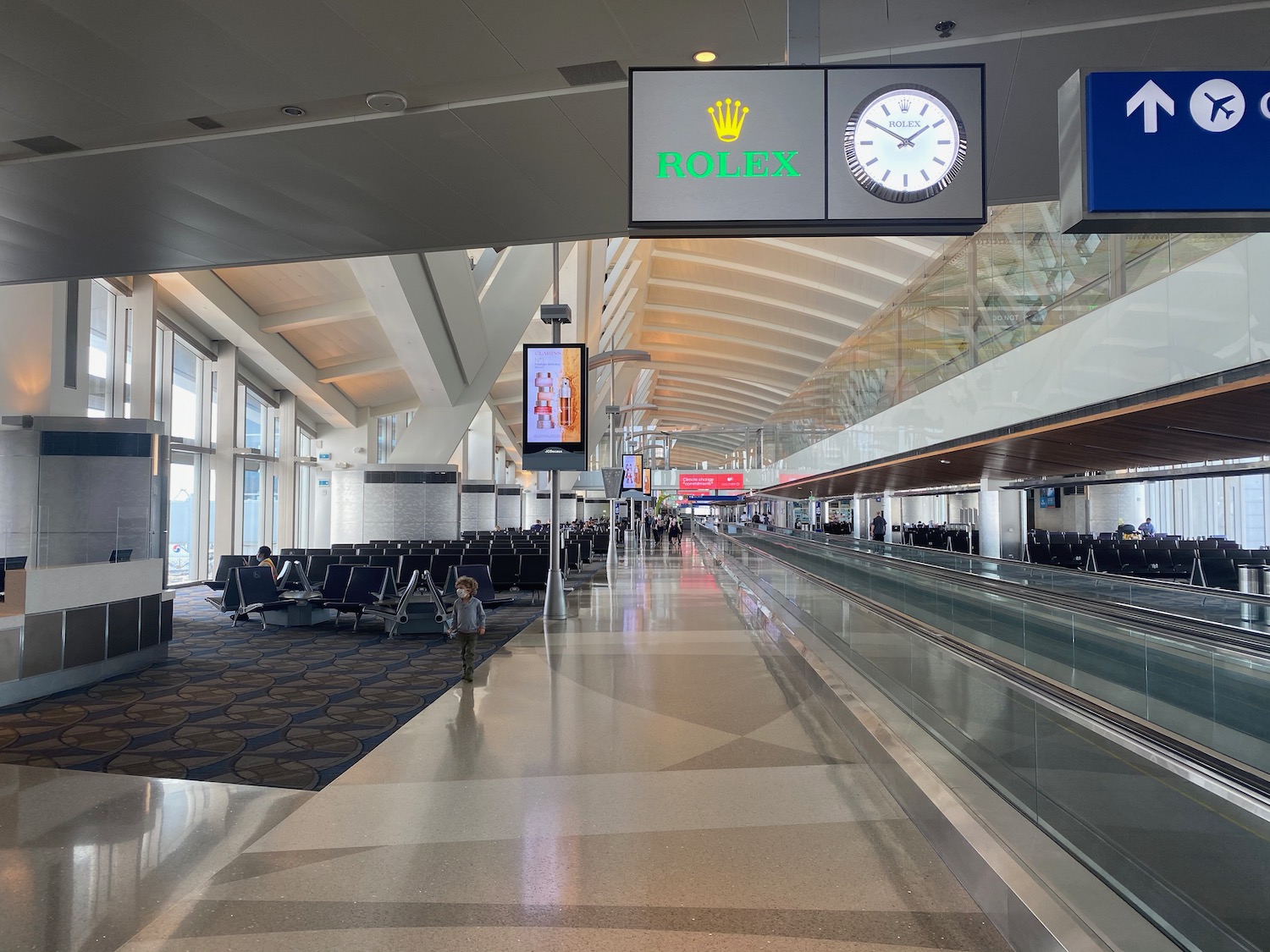 an airport with an escalator and a clock