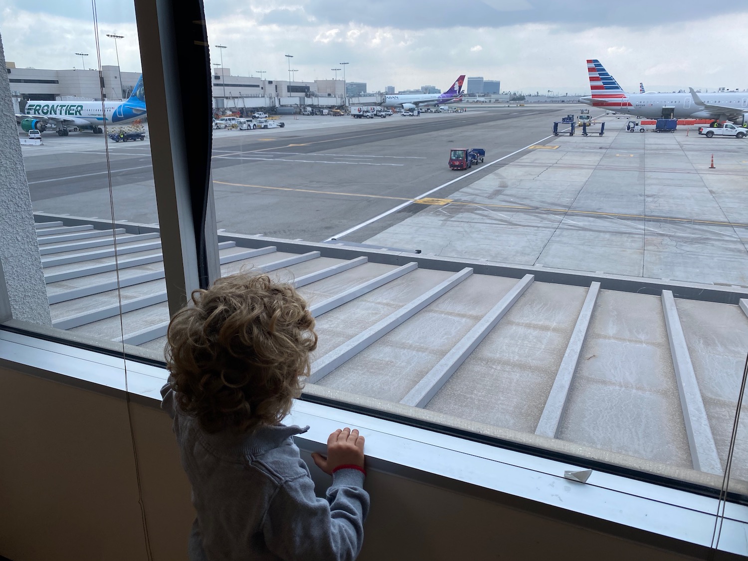 a child looking out a window at an airport