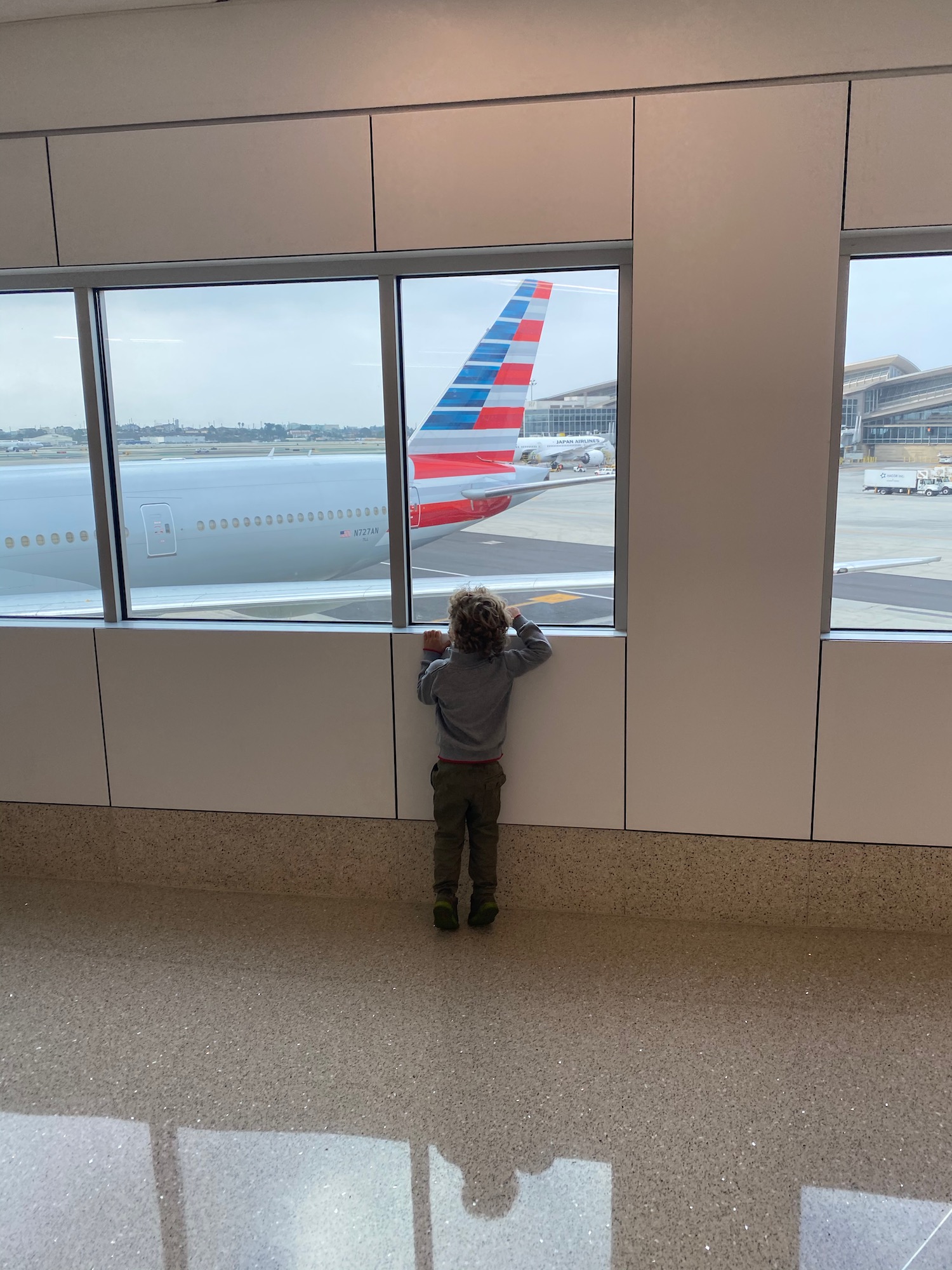 a child looking at an airplane through a window