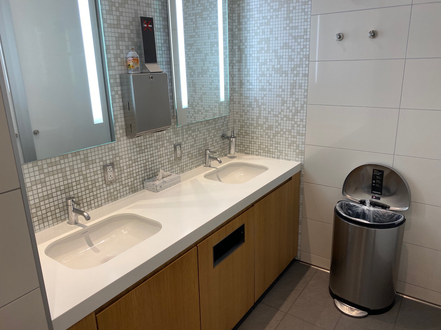 a bathroom with sinks and a trash can