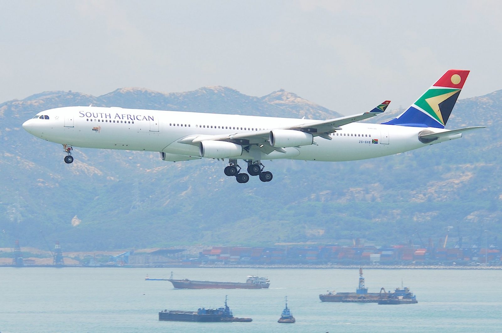 a large white airplane flying over water