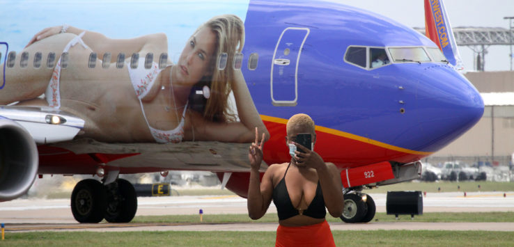 a woman taking a selfie in front of an airplane