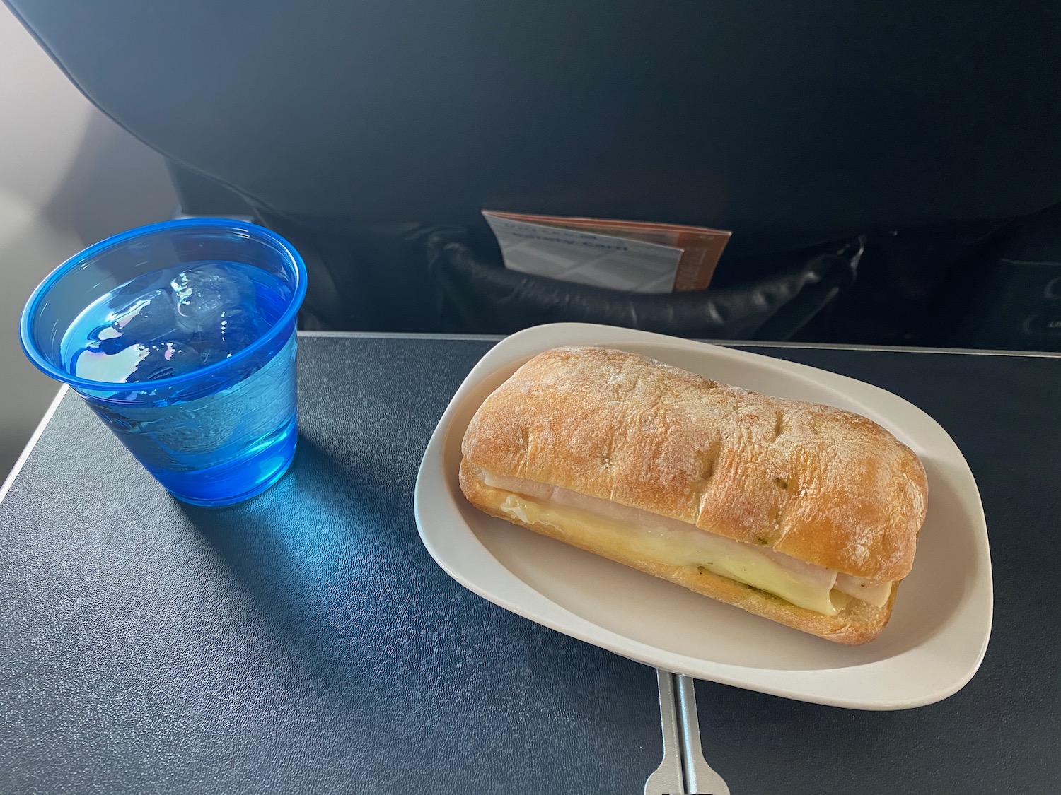 a sandwich on a plate next to a cup of water