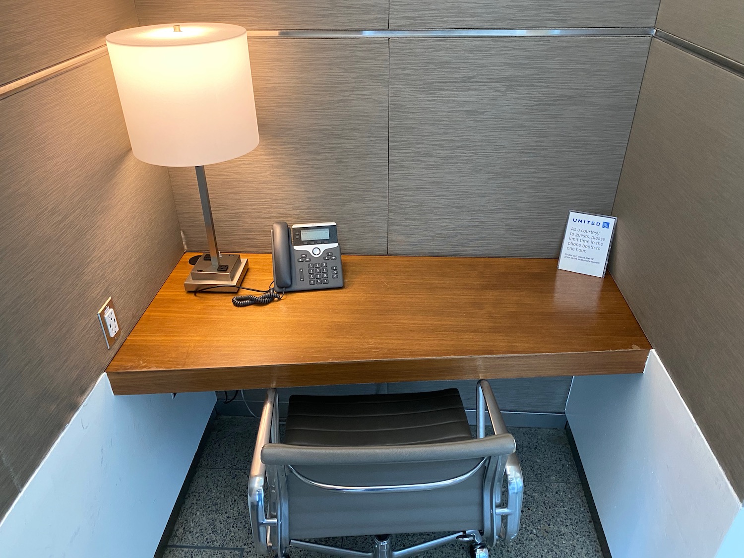 a desk with a telephone and a lamp