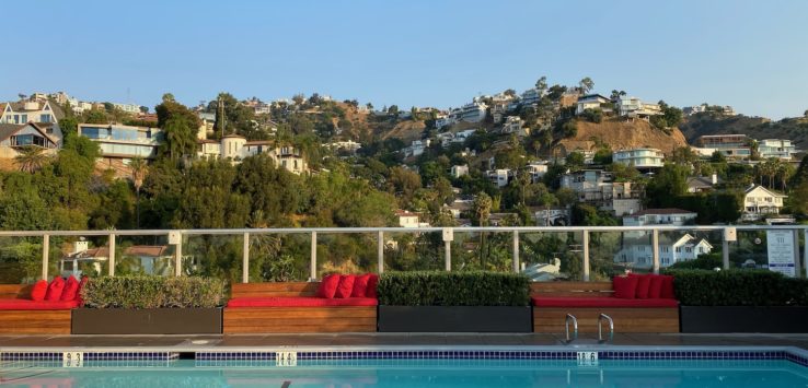 a pool with a view of a hill and buildings