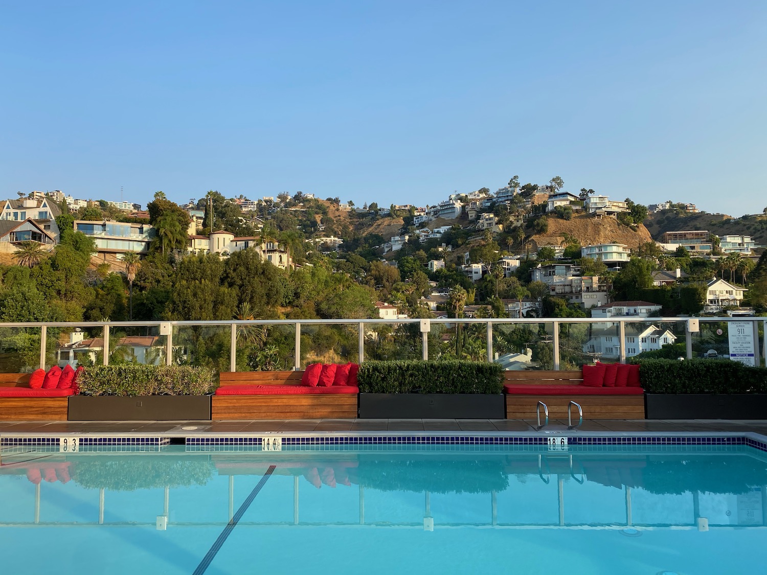 a pool with a view of a hill and buildings