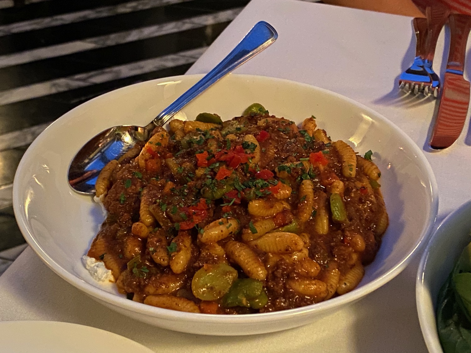 a bowl of pasta with vegetables and a spoon