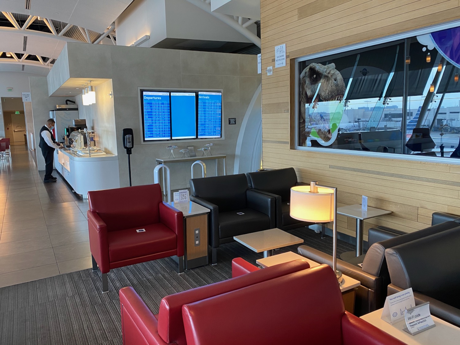 a lounge area with red chairs and a television