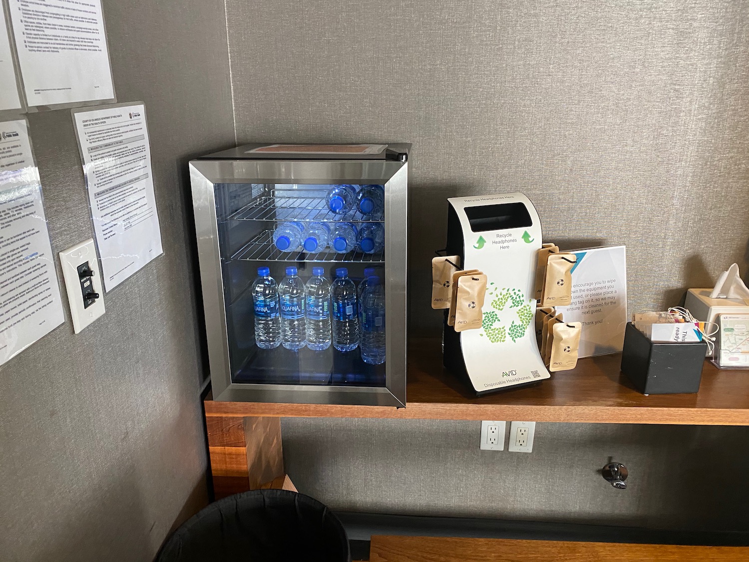 a small refrigerator with bottles of water on a table