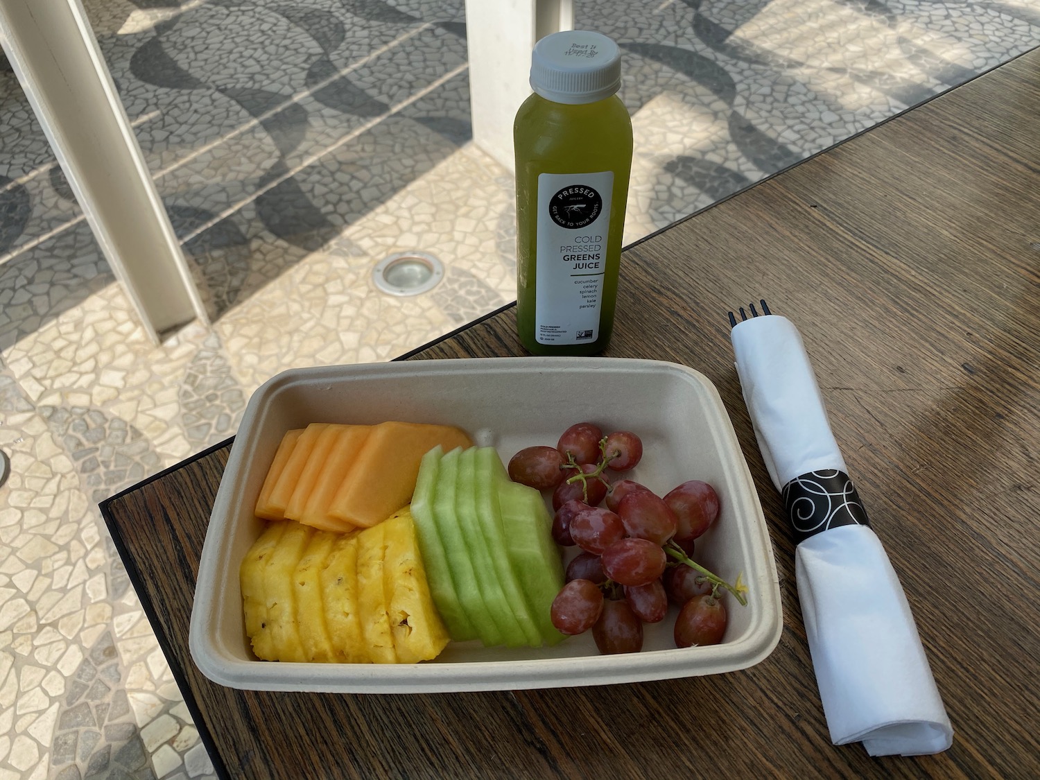 a tray of fruit and a bottle of juice