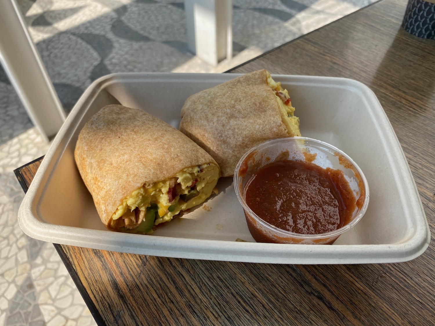 a burrito and salsa in a styrofoam container