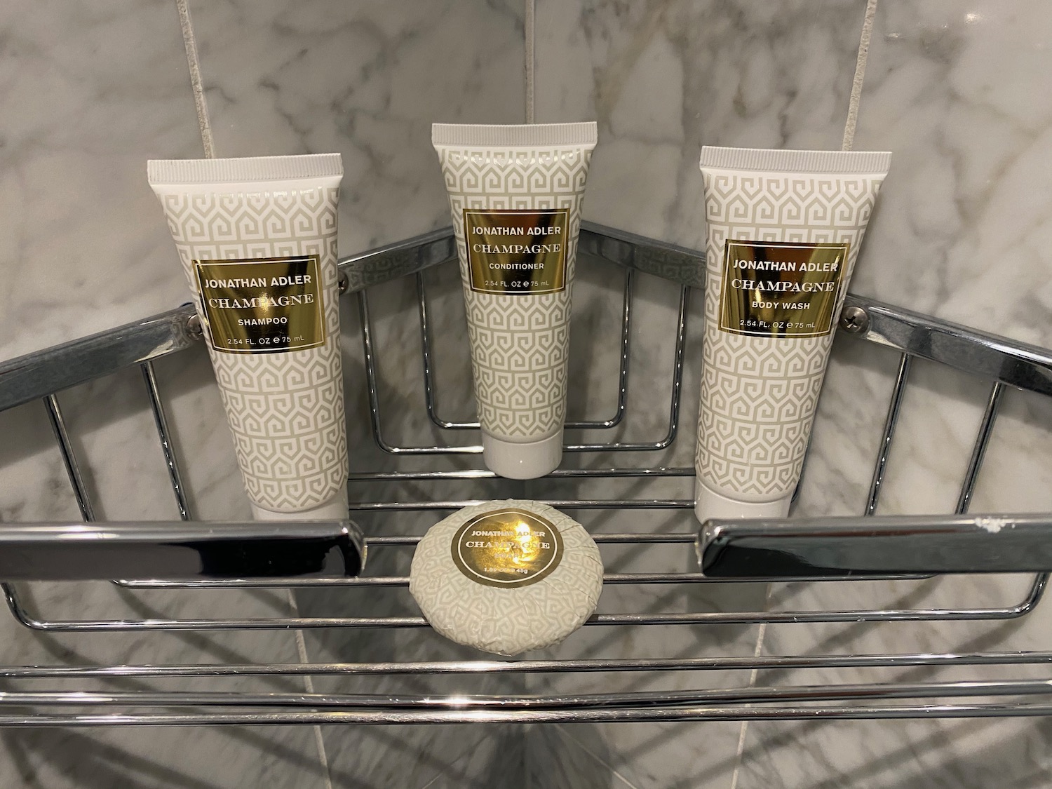 a group of white tubes with gold labels on a metal shelf